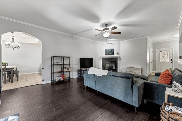 living room featuring crown molding, dark hardwood / wood-style flooring, and ceiling fan with notable chandelier