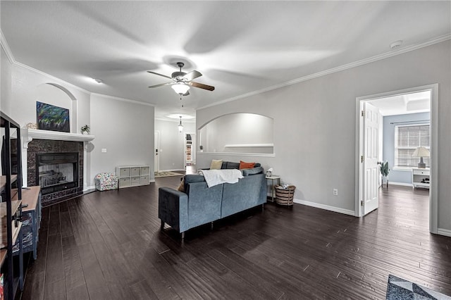 living room with dark hardwood / wood-style flooring, crown molding, and ceiling fan