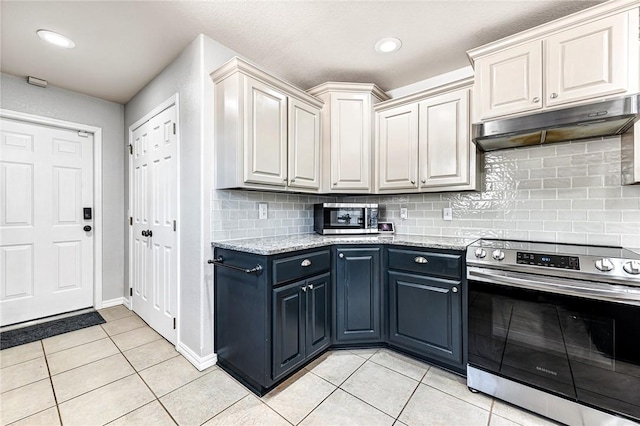 kitchen with stainless steel appliances, light stone countertops, decorative backsplash, and light tile patterned floors