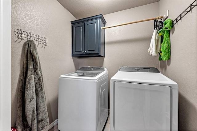 laundry room with cabinets and washing machine and clothes dryer