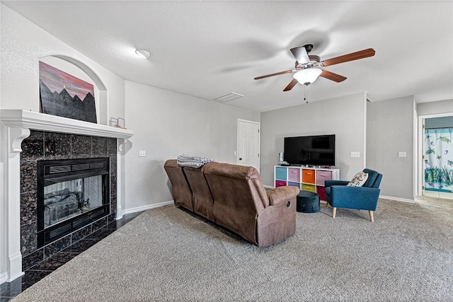 carpeted living room with ceiling fan and a tile fireplace