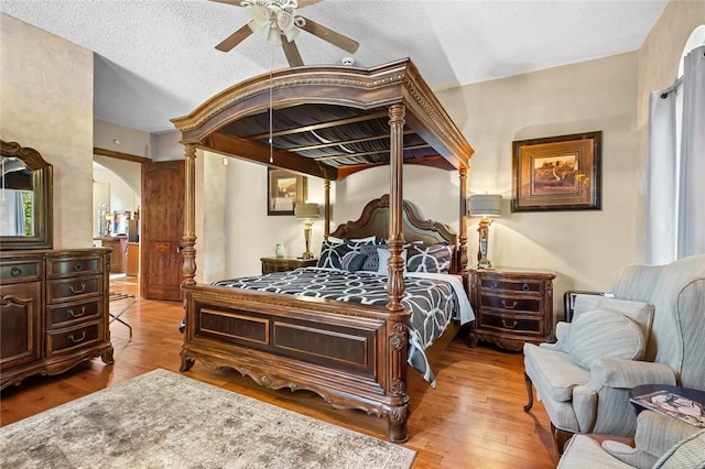 bedroom featuring ceiling fan, a textured ceiling, and light hardwood / wood-style flooring