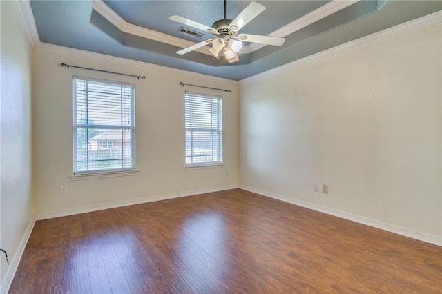 unfurnished room featuring crown molding, ceiling fan, dark hardwood / wood-style flooring, and a tray ceiling