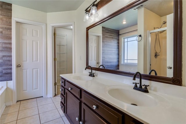 bathroom with tile patterned flooring, vanity, and walk in shower