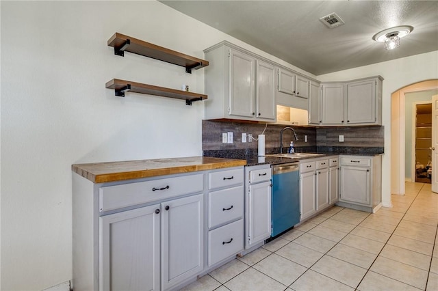 kitchen featuring sink, dishwasher, gray cabinetry, tasteful backsplash, and light tile patterned flooring