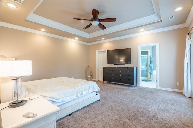 carpeted bedroom featuring crown molding, a tray ceiling, ceiling fan, and ensuite bathroom