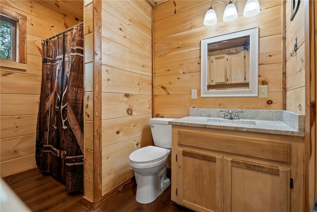 bathroom featuring vanity, toilet, curtained shower, and wood walls