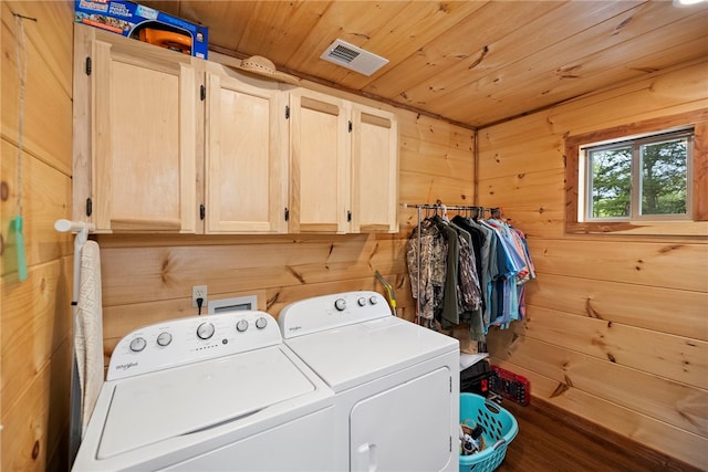 laundry room featuring cabinets, wooden ceiling, wooden walls, and washing machine and clothes dryer