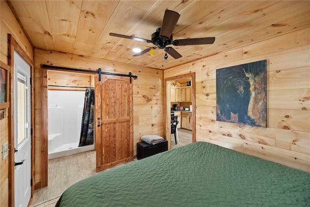 unfurnished bedroom with wood ceiling, wooden walls, a barn door, and hardwood / wood-style flooring