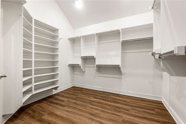 walk in closet with dark hardwood / wood-style flooring and vaulted ceiling