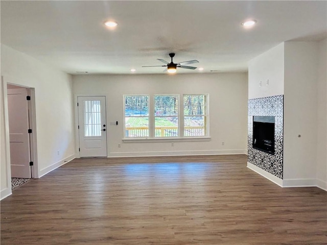 unfurnished living room with dark wood-type flooring and ceiling fan