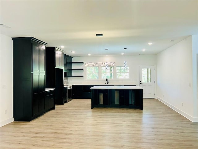 kitchen featuring plenty of natural light, light hardwood / wood-style floors, sink, and a kitchen island