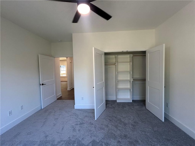 unfurnished bedroom featuring ceiling fan, dark carpet, and a closet