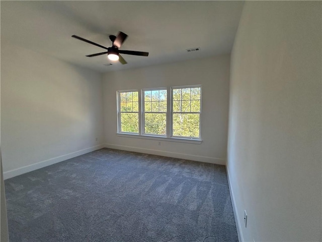 empty room featuring ceiling fan and dark carpet