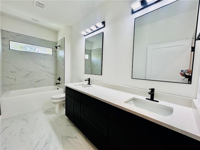 full bathroom with tiled shower / bath, vanity, and toilet