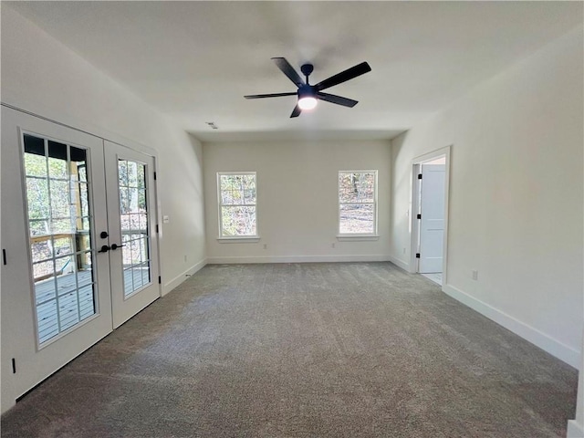 carpeted spare room featuring french doors and ceiling fan