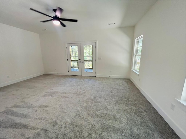 carpeted spare room featuring french doors and ceiling fan