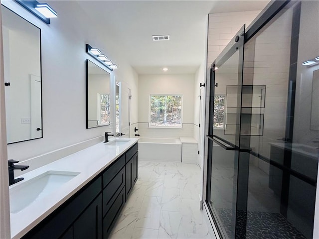 bathroom with vanity and shower with separate bathtub