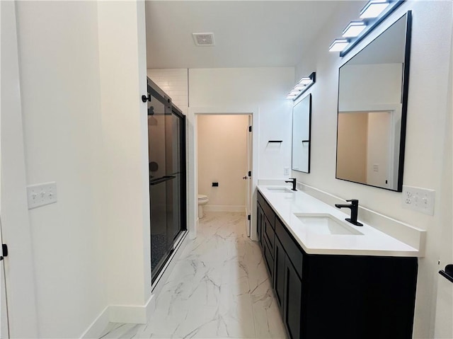 bathroom with vanity, a shower with door, and toilet