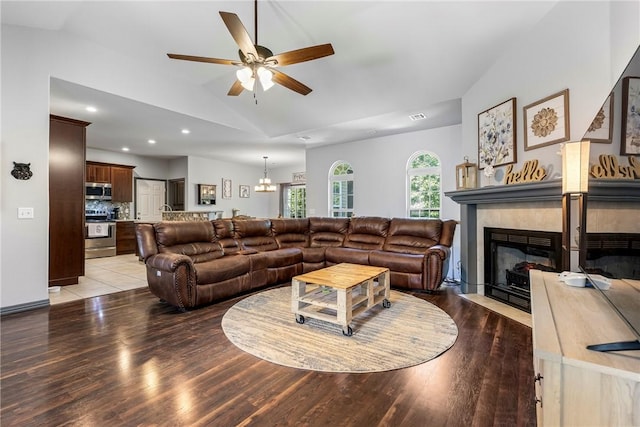 living room with lofted ceiling, hardwood / wood-style floors, and ceiling fan