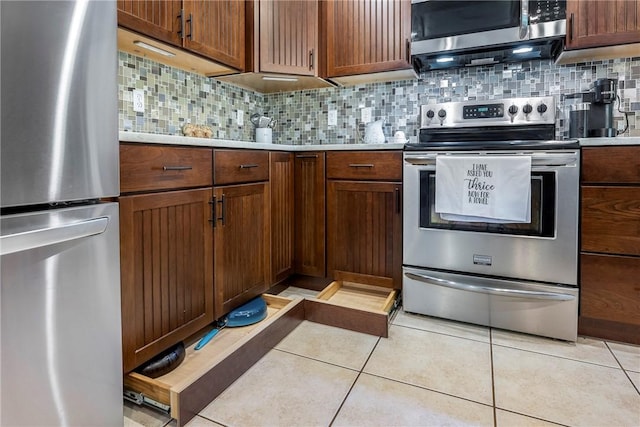 kitchen with stainless steel appliances, light tile patterned floors, and backsplash