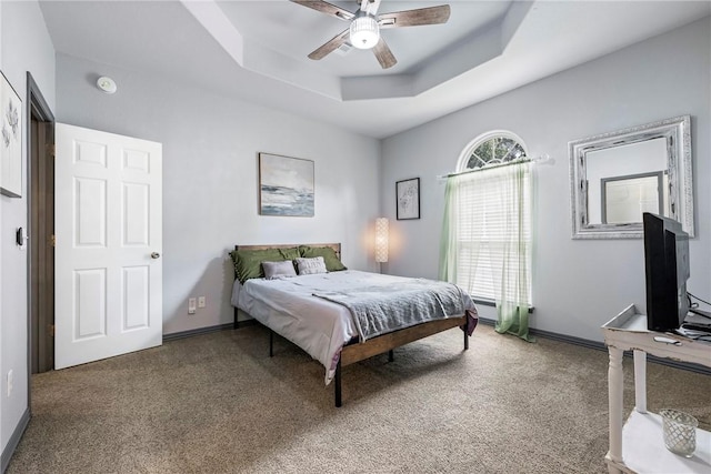 bedroom featuring ceiling fan, a raised ceiling, and carpet floors