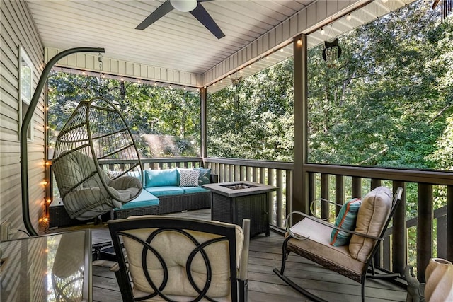 wooden deck with ceiling fan and an outdoor living space with a fire pit