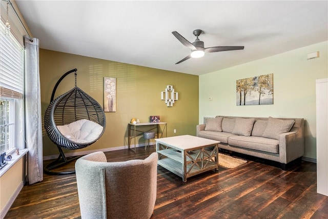 living room featuring dark wood-type flooring and ceiling fan