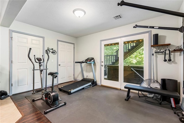 workout area with french doors and a textured ceiling