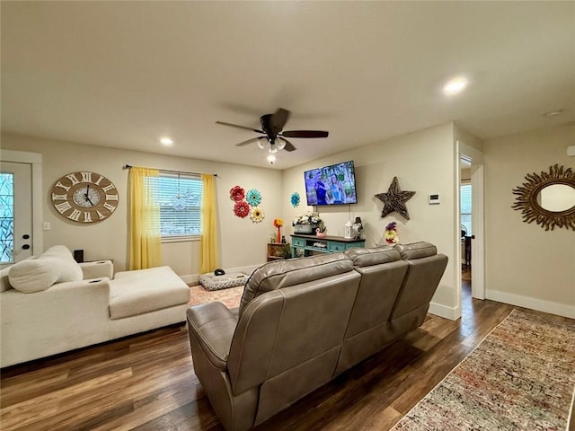 living room featuring dark hardwood / wood-style flooring, a wealth of natural light, and ceiling fan