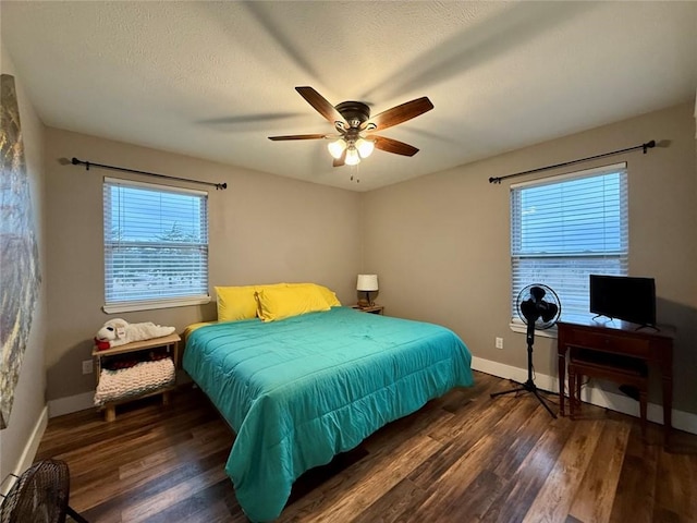 bedroom featuring ceiling fan, dark hardwood / wood-style flooring, and a textured ceiling