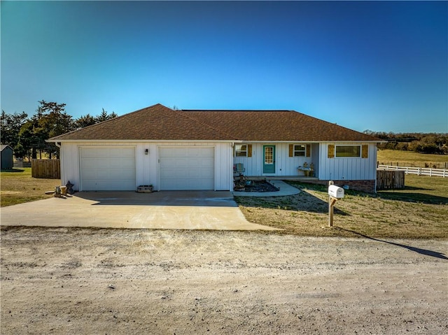 ranch-style house with an attached garage, a shingled roof, fence, concrete driveway, and board and batten siding