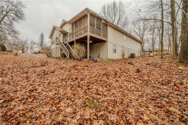 back of property featuring a wooden deck, a sunroom, and central air condition unit