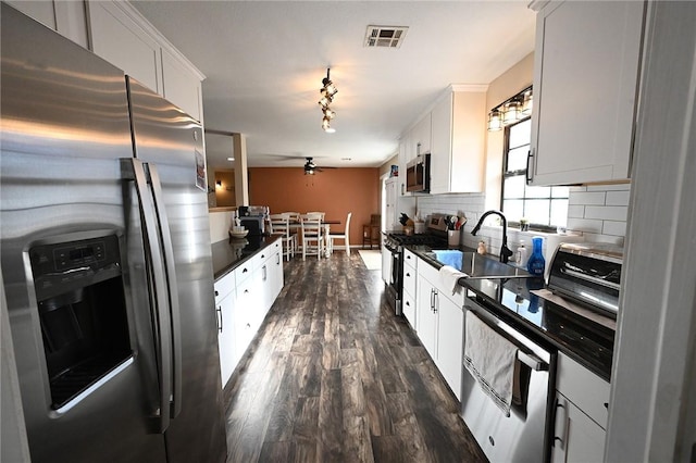 kitchen with white cabinetry, backsplash, dark wood-type flooring, and stainless steel appliances