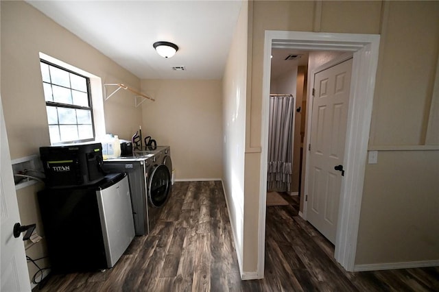 clothes washing area featuring dark hardwood / wood-style floors and washer and clothes dryer