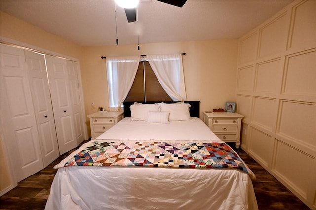 bedroom featuring dark wood-type flooring, ceiling fan, and a closet