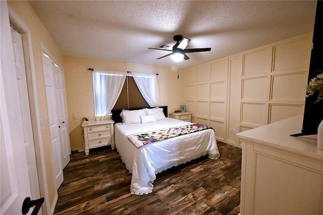 bedroom featuring ceiling fan, a textured ceiling, and dark hardwood / wood-style flooring