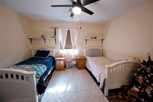 bedroom with ceiling fan, a textured ceiling, and carpet