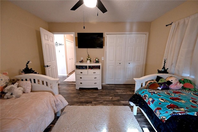 bedroom featuring dark wood-type flooring, a closet, and ceiling fan