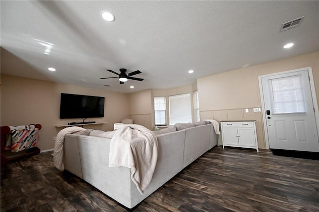 living room with ceiling fan, a textured ceiling, and dark hardwood / wood-style flooring