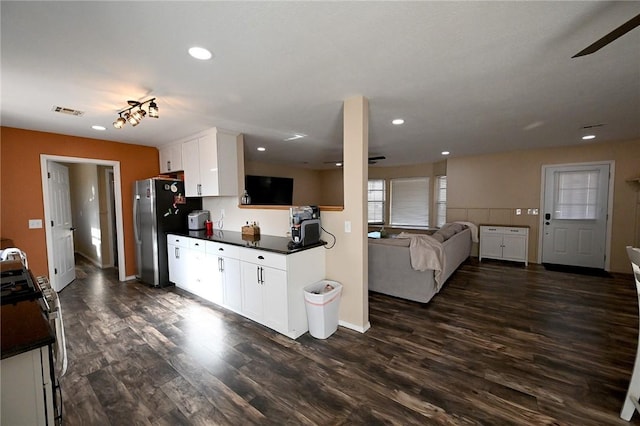 kitchen with appliances with stainless steel finishes, dark wood-type flooring, white cabinets, and ceiling fan