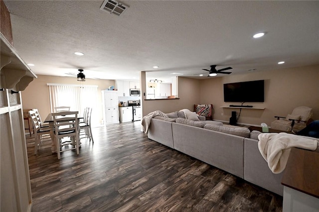 living room with ceiling fan, a textured ceiling, and dark hardwood / wood-style flooring