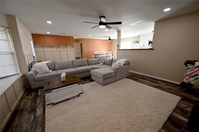 living room featuring ceiling fan and dark hardwood / wood-style floors