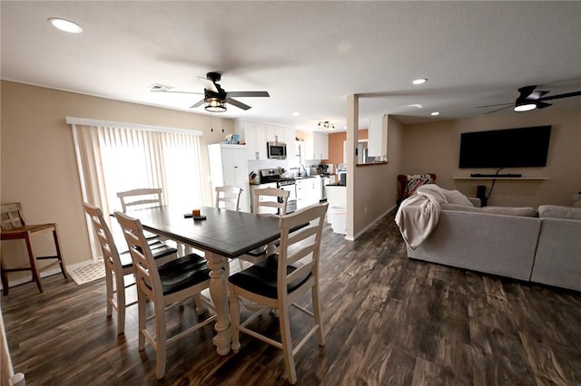 dining area with dark wood-type flooring and ceiling fan