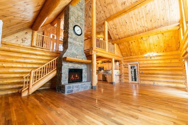 unfurnished living room with wood-type flooring, a stone fireplace, high vaulted ceiling, and beam ceiling