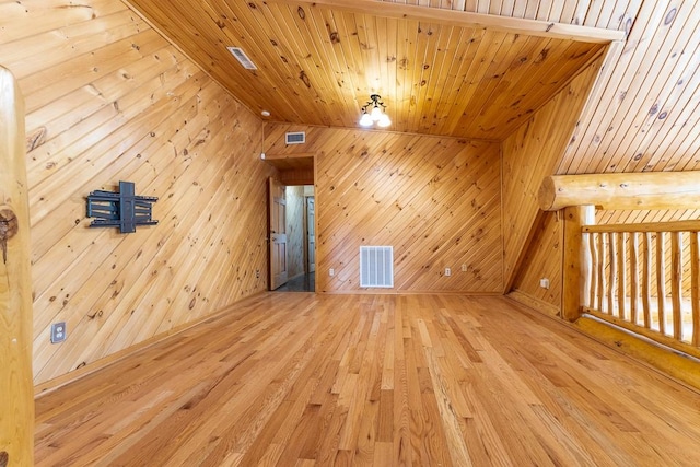 bonus room with wood ceiling, wood walls, wood finished floors, and visible vents