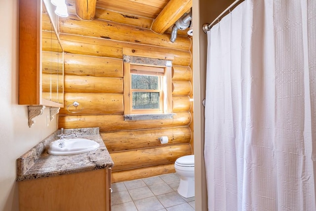 bathroom featuring toilet, curtained shower, tile patterned flooring, vanity, and beam ceiling