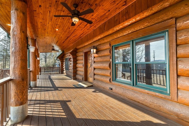 wooden terrace with covered porch and a ceiling fan