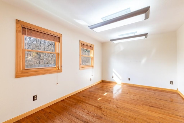 unfurnished room featuring baseboards and light wood-style floors