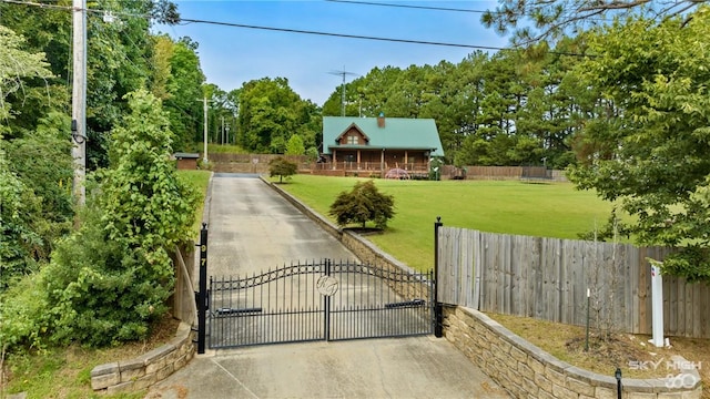 view of gate with a yard and fence